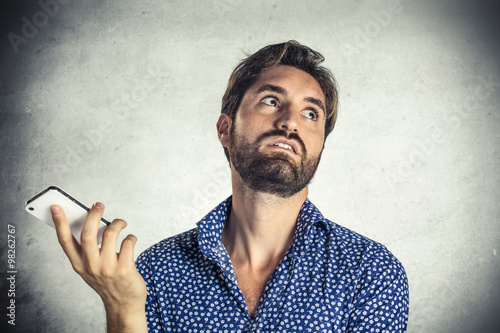 Annoyed young man at mobile phone