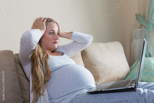 pregnant woman spends time a laptop