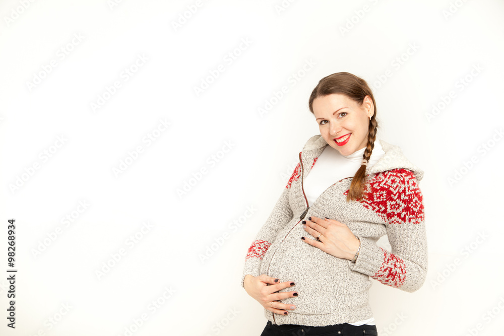 Happy, young pregnant woman in a winter clothing on a white background Happy, young pregnant woman in a winter clothing on a white background