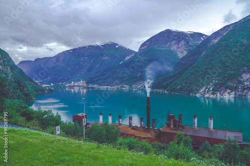 Factory with working chimney in the mountains near cler blue lake