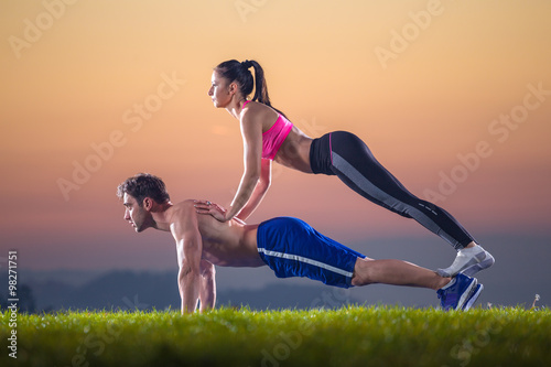 fitness pair exercise push ups on sunset