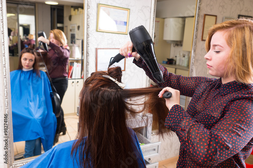 Stylist Blow Drying Hair of Client in Salon