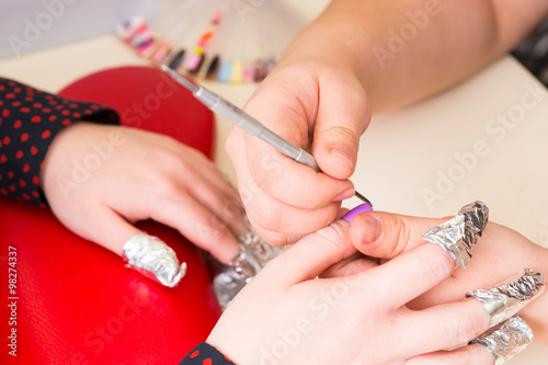 Manicurist Shaping Finger Nails with Tool in Spa
