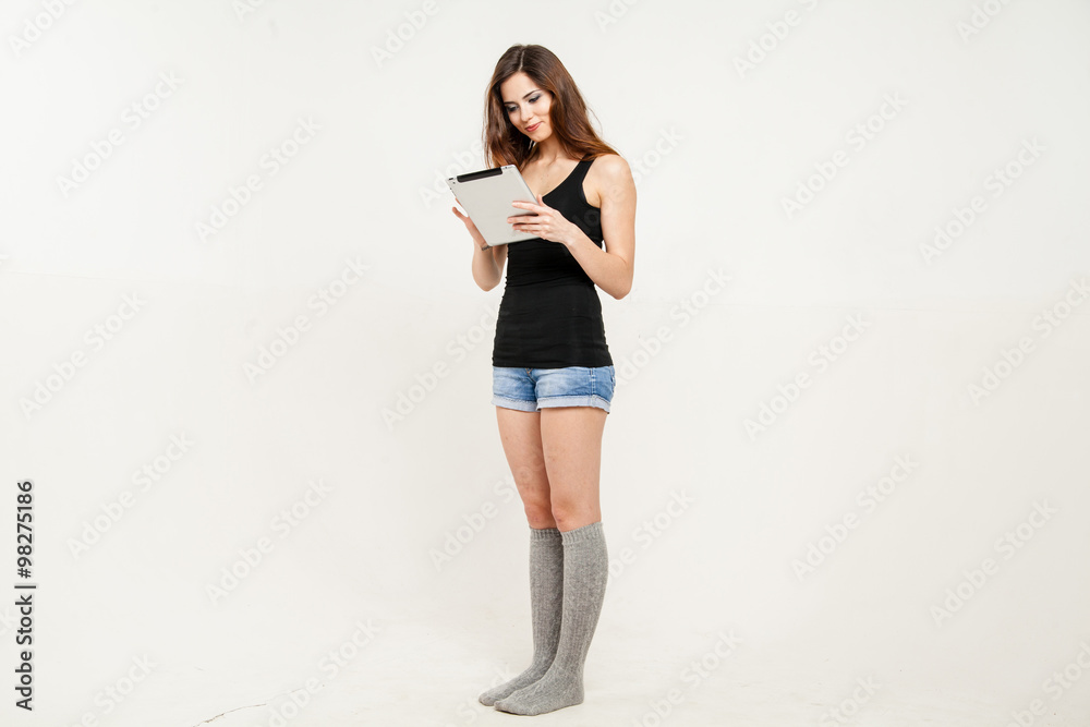 Young beautiful businesswoman holding digital tablet in her hands while standing isolated on white Young beautiful businesswoman holding digital tablet in her hands while standing isolated on white