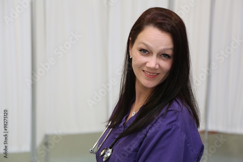 Portrait of attractive female nurse with stethoscope on white background with copy space photo