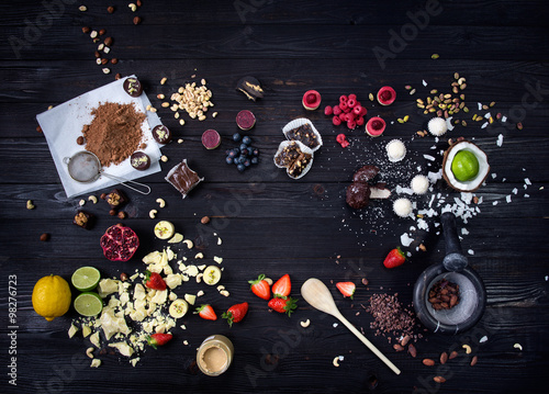 Raw cakes and fresh fruits
Raw cakes, fresh fruits and nuts for desserts beautifully arranged on a black wooden table.