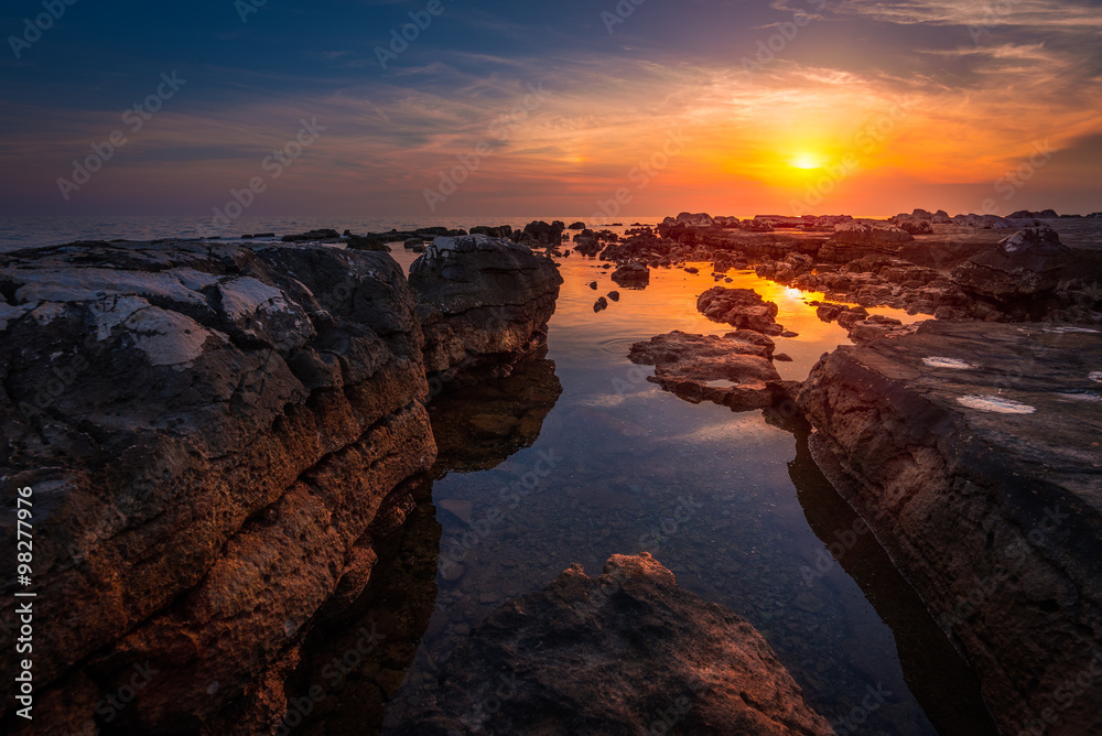 Beautiful Vibrant Sunset Over the Sea with Rocks in Foreground