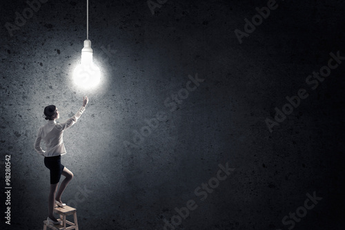 Businesswoman reaching light bulb