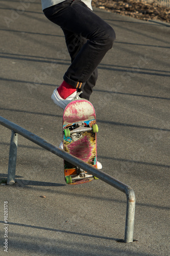 Skateboarder jumping to make railslide photo