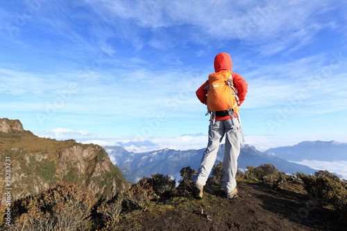 young woman hiker hiking on mountain peak
