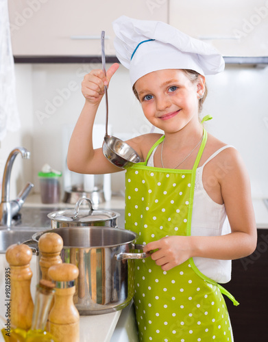 Cute little girl at home kitchen photo