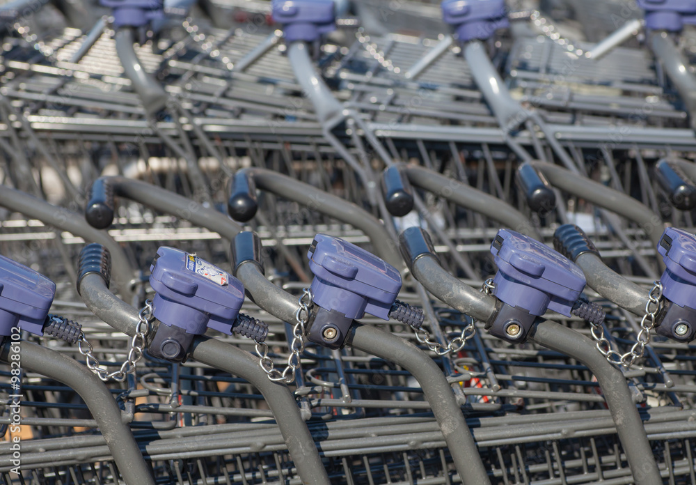 Rows of shopping carts at supermarket entrance..