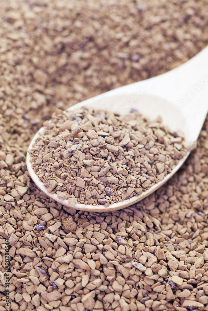 Granules of instant coffee in wooden spoon Granules of instant coffee in wooden spoon