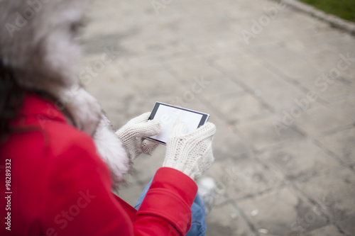 Mobile phone in hands with glowes, cold weather