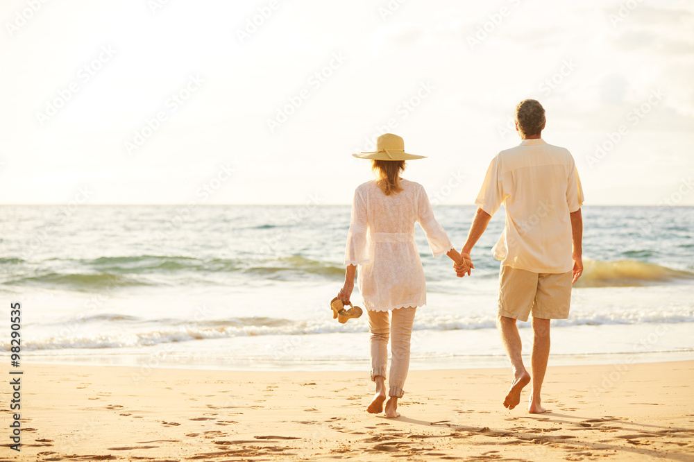Mature Couple Walking on the Beach at Sunset Mature Couple Walking on the Beach at Sunset