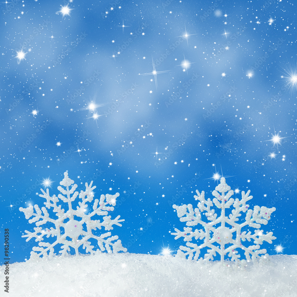 Christmas background with two decorative snowflakes in snow