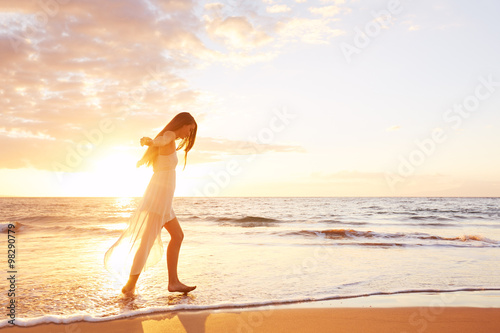 Fototapeta Naklejka Na Ścianę i Meble -  Happy Carefree Woman Dancing on the Beach at Sunset