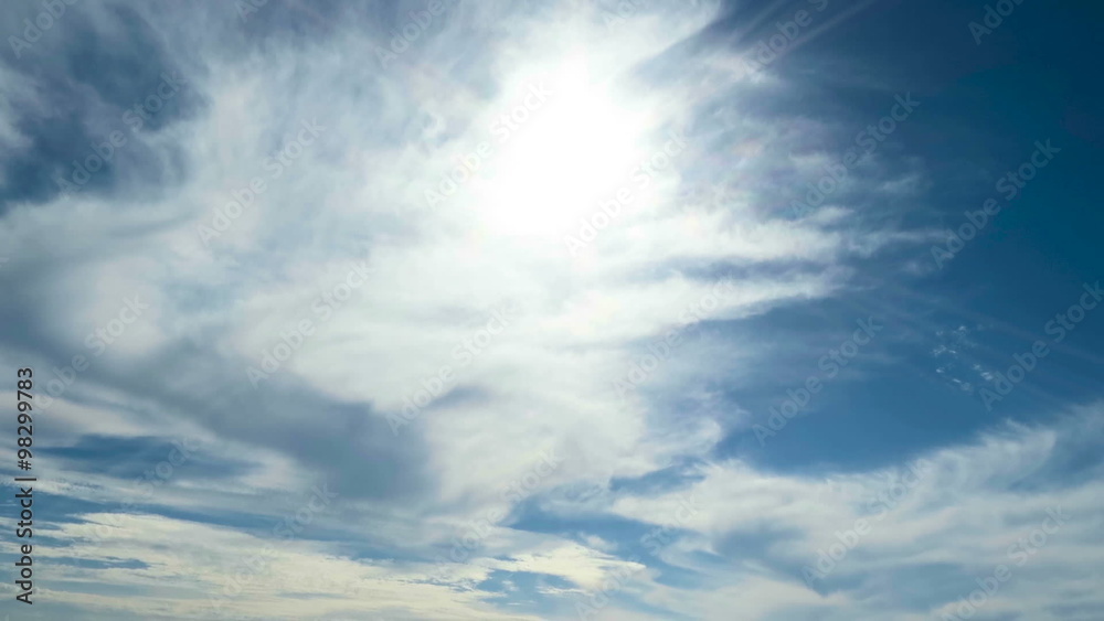 blue sky with sun and sunbeams and white and grey clouds running fast speed blue sky with sun and sunbeams and white and grey clouds running fast speed