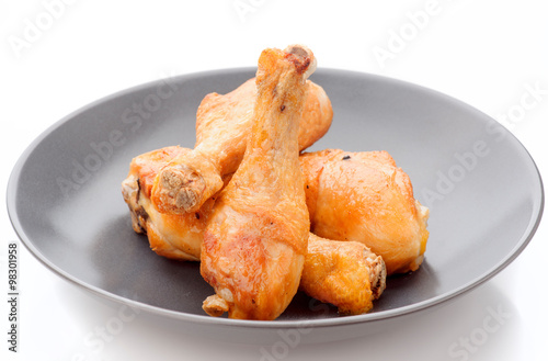 fried chicken thighs in dark porcelain dish