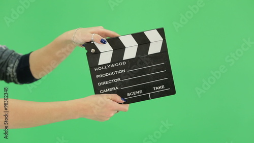 hand girl with clapperboard on the green screen photo