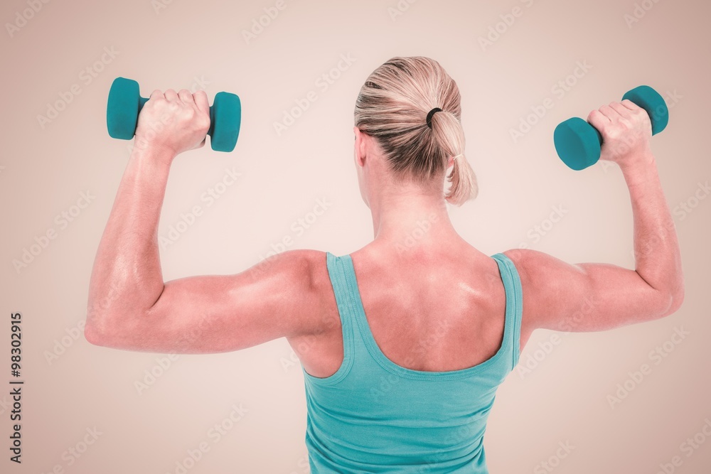 Composite image of muscular woman exercising with dumbbells Composite image of muscular woman exercising with dumbbells