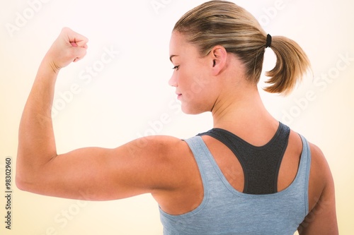 Composite image of rear view of muscular woman flexing muscles 
