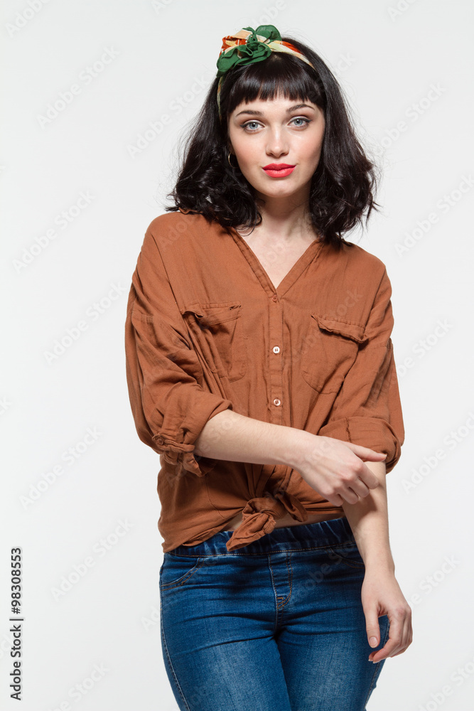 Fototapeta premium Beautiful confident young woman in blouse and jeans