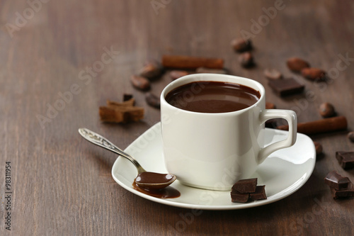 Cacao with chocolate and cinnamon on wooden table
