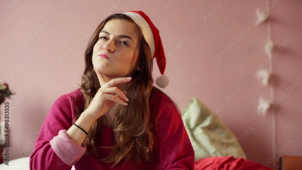 Teenage girl wearing Santas hat and smiling to the camera
Teenage girl wearing Santas hat and smiling to the camera