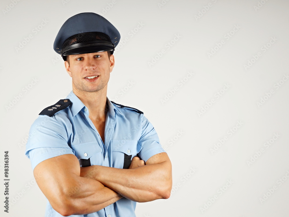 Portrait of smiling muscular policeman in police cap, you can write some text in right