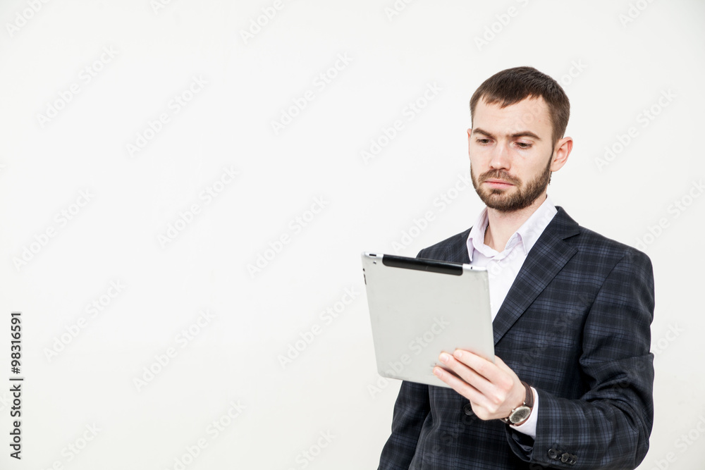 Portrait of a handsome young bearded man wearing a formal black suit holding a tablet Portrait of a handsome young bearded man wearing a formal black suit holding a tablet