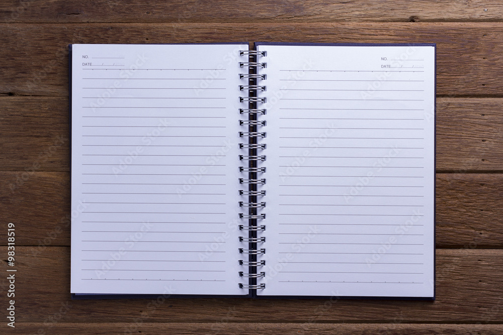 Note book paper on dark wood background Note book paper on dark wood background