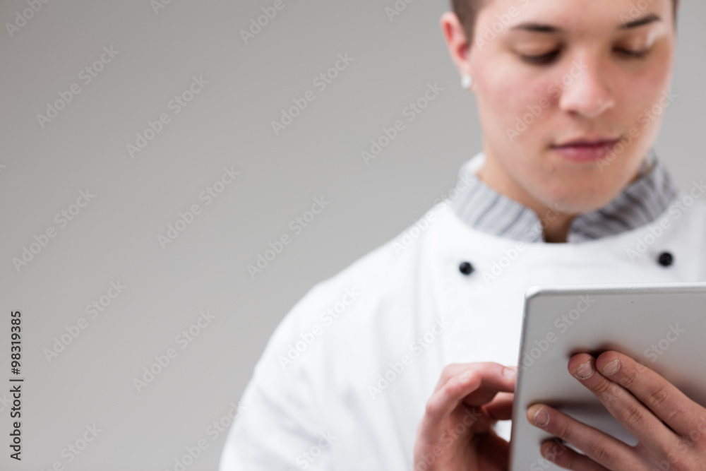 young chef ordering online with his tablet young chef ordering online with his tablet