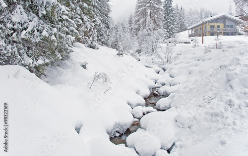 Stream meandering through snow in winter