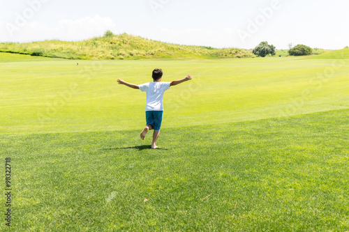 Little kid running on green meadow