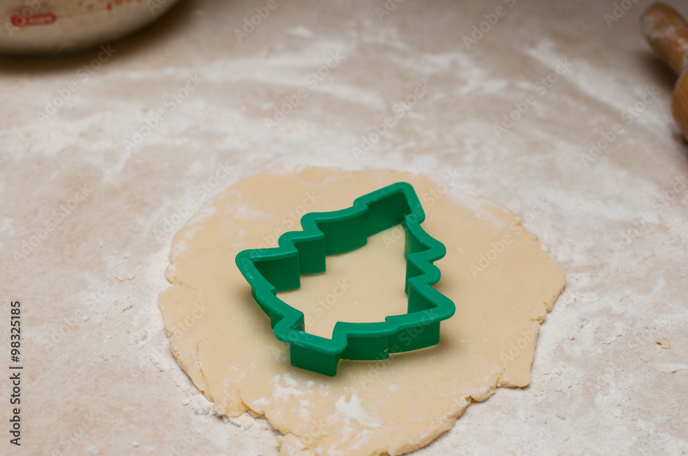 christmas tree cookie cutter on rolled out dough