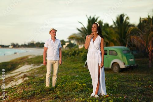 Photography stylish couple standing on the beach and palms