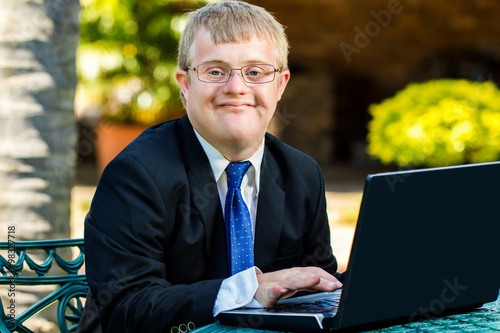 Young handicapped businessman working with laptop.