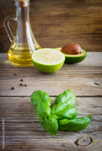 Sprig of basil in the background avocado, lime and olive oil. © colnihko