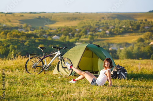 Travel with bicycle alone - young woman in the tent