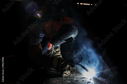 Worker fabricate structure by flux cored wire arc welding process