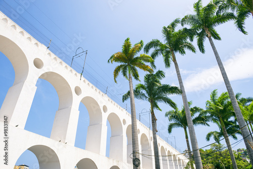 Arcos da Lapa Arches Rio de Janeiro Brazil under bright blue tropical blue sky with palm trees
