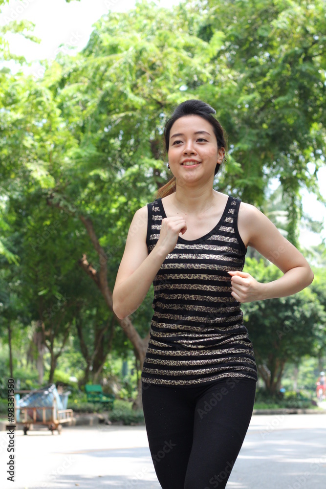 Portrait of thai adult beautiful girl doing running exercises in the park Portrait of thai adult beautiful girl doing running exercises in the park