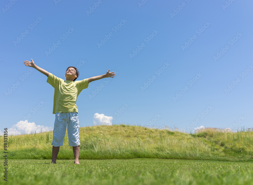 Boy with open hands in beautiful nature