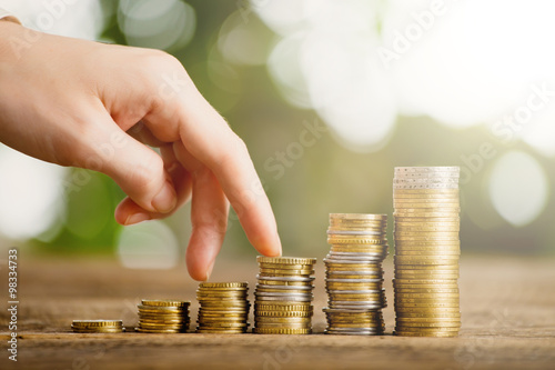 Foto Woman finger go up by coin rating chart on wooden background and