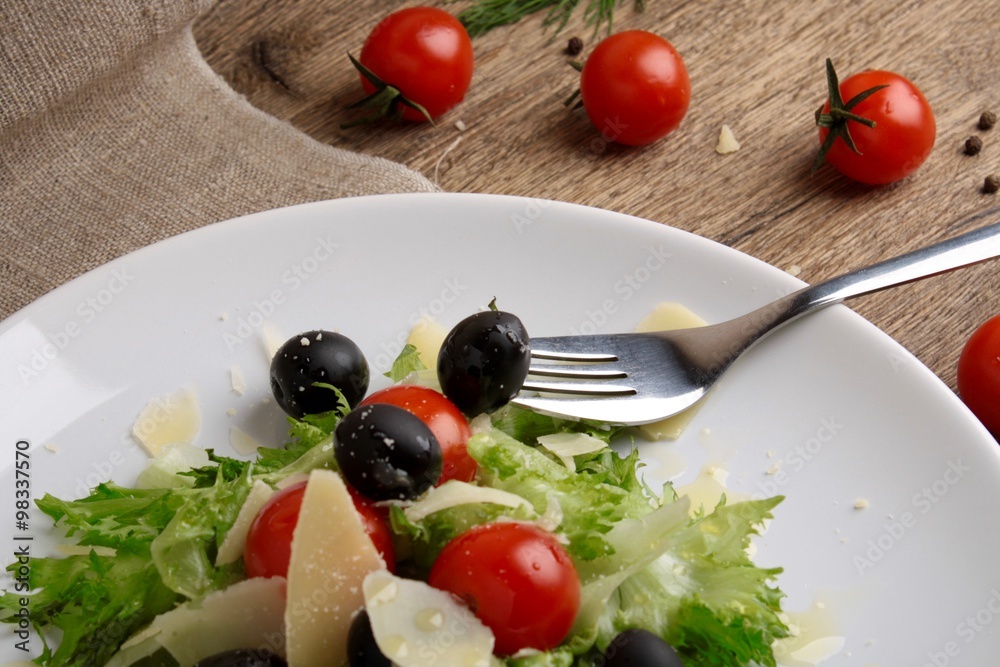 Fresh vegetables salad with tomatoes , olives , parmesan cheese
