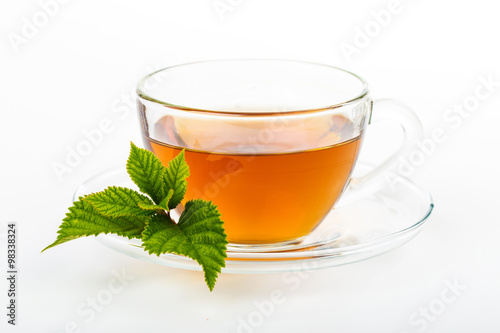 Glass Cup Tea with camomile flower and Mint Leaf, on white