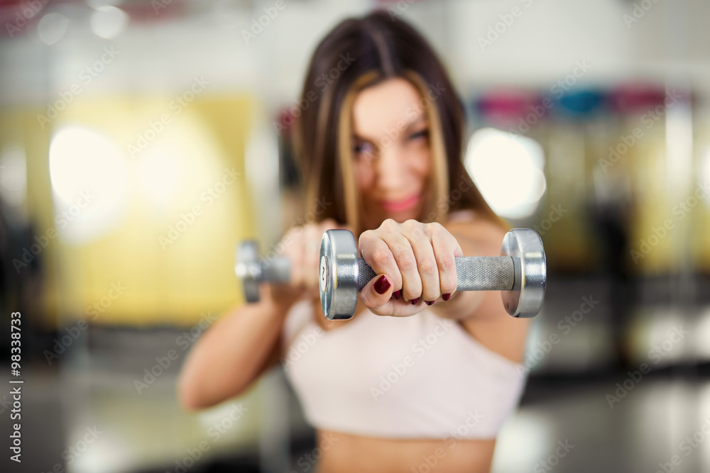 Gorgeous brunette lifting some weights and working on her biceps