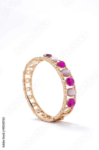 gold bracelet with pink stones on white background