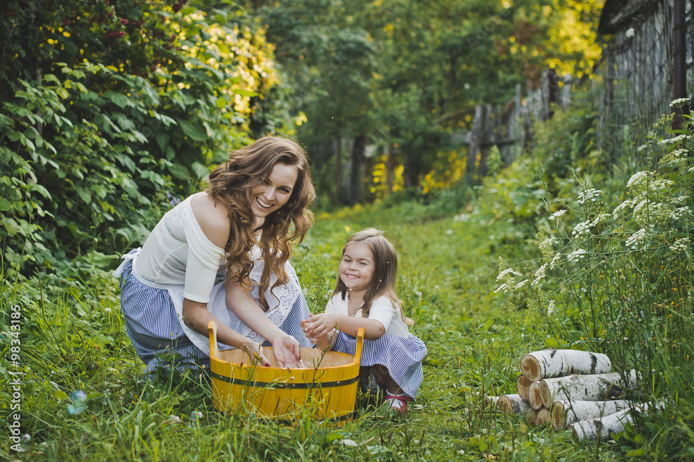 Fototapeta premium Daughter with mother washing clothes in nature 4706.